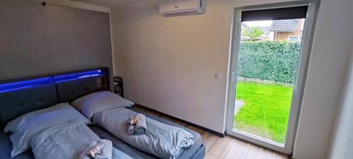 1 dormitorio con 2 camas y ventana grande en Gemütlicher Bungalow nähe Volksparkstadion, en Hamburgo