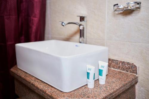a white sink and two toothbrushes on a counter at Grand Pyramid View Hotel in Cairo