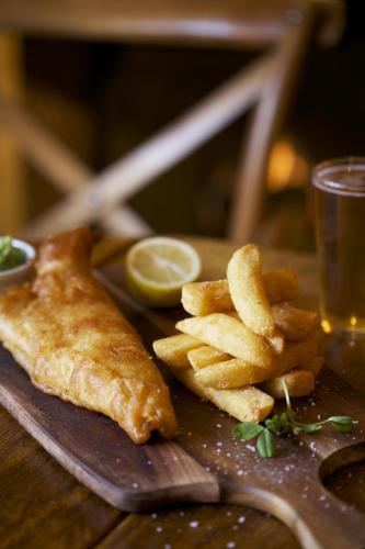 a plate of food with a piece of fish and french fries at The Bear Of Rodborough Hotel in Stroud