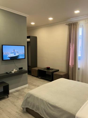 KʼanakʼerravanにあるHaya Guest Houseのベッドと薄型テレビのある寝室