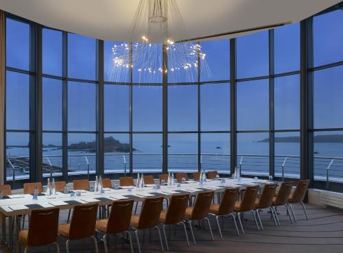 a long table in a large room with windows at Radisson Blu Waterfront Hotel, Jersey in Saint Helier Jersey