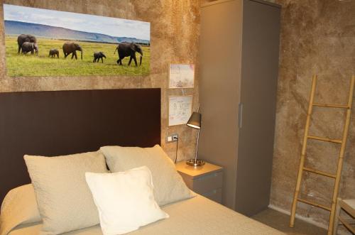a bedroom with a bed with a painting of elephants at Masia Cal Sisplau, con piscina y rodeada de viñedos a 10 minutos de Vilafranca del Penedés, Barcelona ,Cataluña in San Martín Sarroca