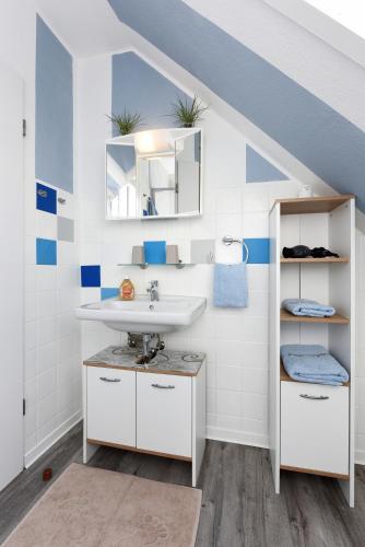 a bathroom with a sink and a mirror at Ferienwohnung Ankerplatz im Gästehaus Kock in Neuharlingersiel
