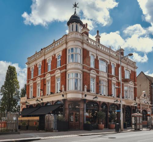 a large brick building with a tower on top at The Black Lion Pub & Boutique Guesthouse in London