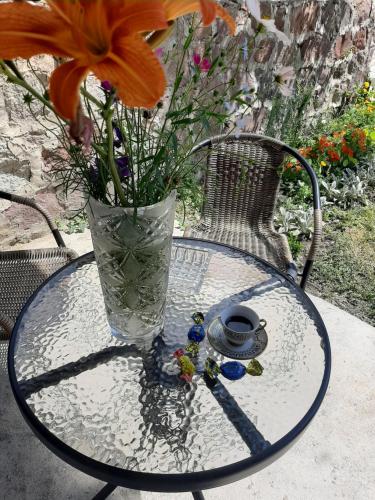 a glass table with a vase and flowers on it at Royal Galaxy in Kazbegi