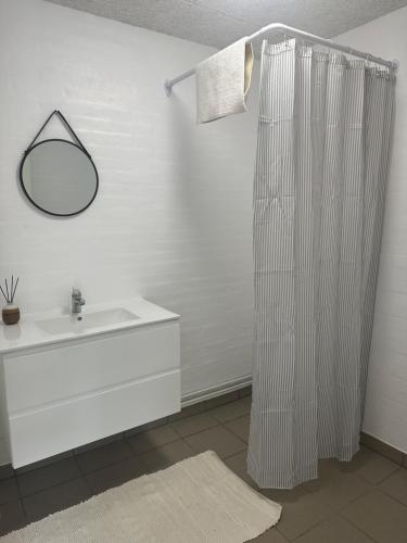 bagno con tenda da doccia bianca e lavandino di Vestervang bed and breakfast a Nykøbing Mors