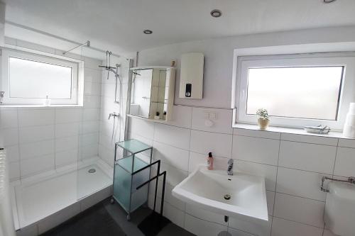 bagno bianco con lavandino e doccia di Apartment Meerbusch a Meerbusch