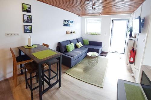un soggiorno con divano blu e tavolo di Apartment Meerbusch a Meerbusch