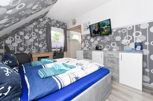 Apartment Meeresrauschen im Gästehaus Kock في نايهالينجازييل: غرفة نوم بها سرير وتلفزيون على الحائط