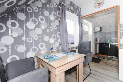 Apartment Meeresrauschen im Gästehaus Kock في نايهالينجازييل: غرفة طعام بها طاولة وكراسي