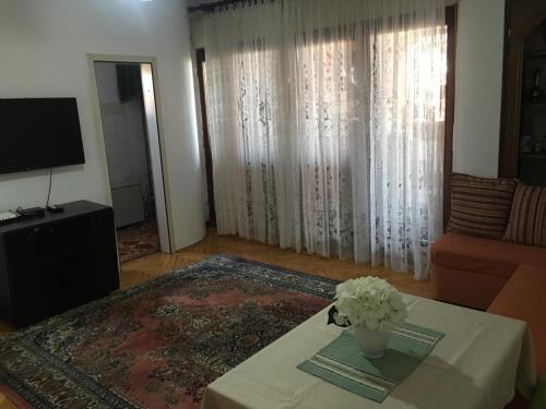 a living room with a table with a vase of flowers on it at Central Center Peja in Peje