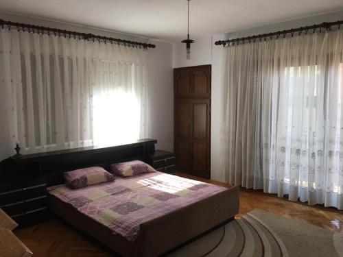 a bedroom with a bed and a window with curtains at Central Center Peja in Peje