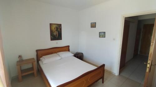 a bedroom with a bed in a white room at Vasiliki's apartment in Sparta