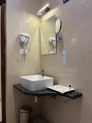 a bathroom with a sink and a mirror at VOVO PREMIER HOTEL in Bengaluru