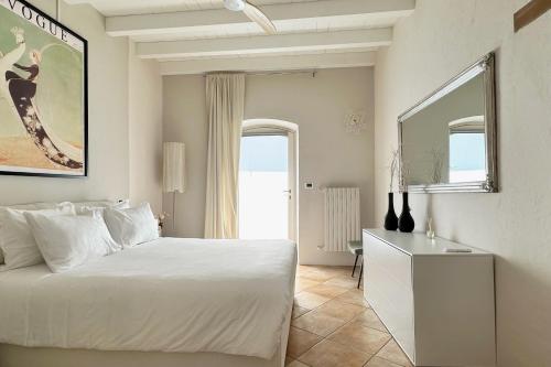 een slaapkamer met een bed, een dressoir en een spiegel bij Borgo dei Sogni - Deluxe Apartment - Lago di Garda in San Felice del Benaco