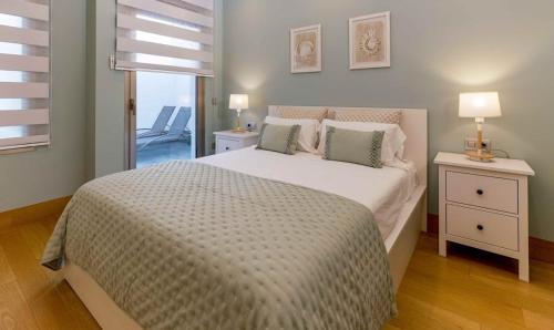 1 dormitorio con 1 cama con edredón blanco en Villa BLUE PORTOFINO Los Cristianos, POOL, en Los Cristianos