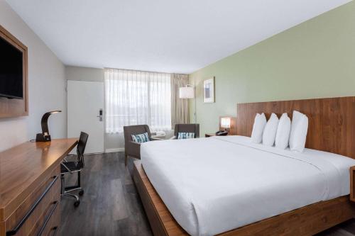 um quarto de hotel com uma cama grande e uma secretária em Ramada by Wyndham Altamonte Springs Near I-4 em Orlando