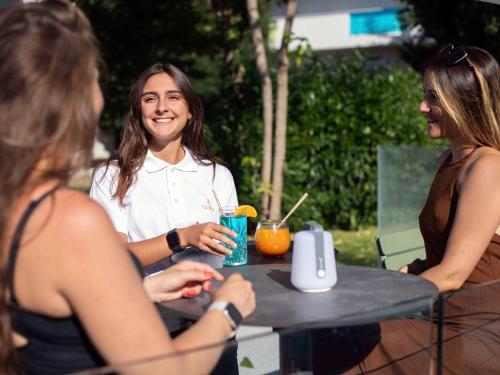 Un groupe de trois femmes assises à une table dans l'établissement Novotel Montpellier, à Montpellier