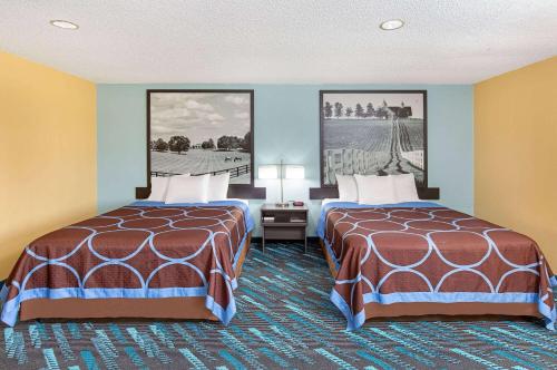 a hotel room with two beds and two pictures on the wall at Super 8 by Wyndham Somerset in Somerset