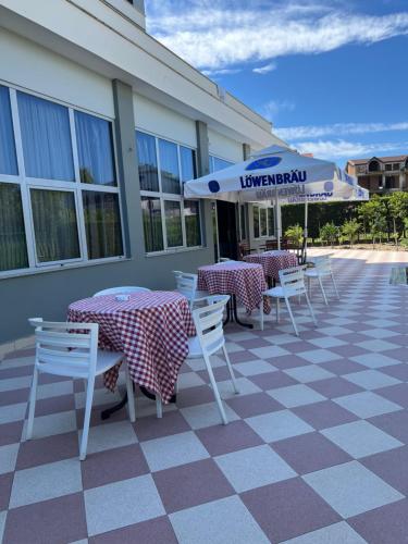 een patio met tafels en stoelen en een parasol bij Blue Sky in Golem