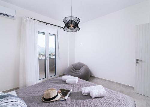a bedroom with a bed with a hat and a chair at Athena Home South Crete in Kapparianá