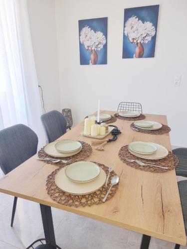 a wooden table with plates and napkins on it at Athena Home South Crete in Kapparianá