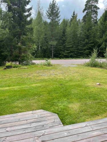a field of green grass with a wooden deck at Torp ved Mårbacka (Helt hus til leie) Östra Ämtervik/ Sunne in Östra Ämtervik