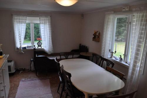 a dining room with a table and chairs and windows at Torp ved Mårbacka (Helt hus til leie) Östra Ämtervik/ Sunne in Östra Ämtervik
