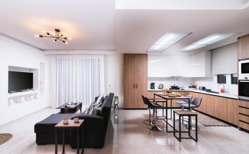 a living room and kitchen with a couch and chairs at Athena Home South Crete in Kapparianá