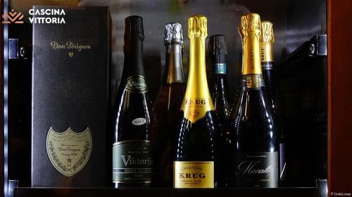a group of bottles of wine on a shelf at Cascina Vittoria Restaurant Lab & Rooms in Rognano
