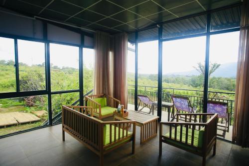 a room with a balcony with chairs and windows at Ventosa Homefarm Măng Đen in Kon Von Kla
