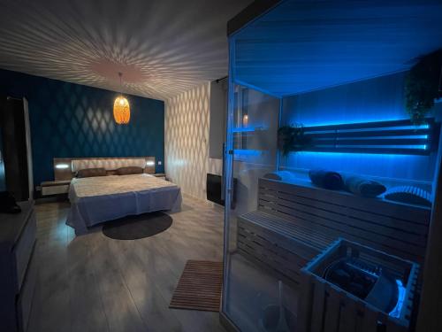 1 dormitorio con 1 cama y una iluminación azul en Sauna en bord de rivière en Morez