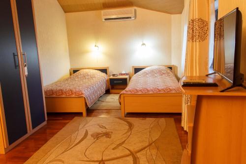 a hotel room with two beds and a desk at Starye Bendery in Bender