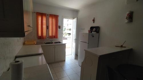 a kitchen with a white refrigerator and a window at Vasiliki's apartment in Sparta