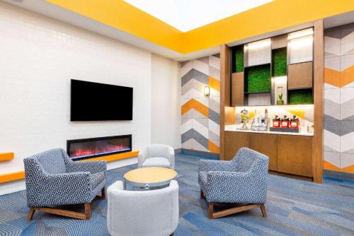 a waiting room with two chairs and a fireplace at La Quinta by Wyndham St. George in St. George