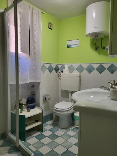 y baño con aseo blanco y lavamanos. en Casa Marino, en Stia