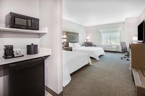 een hotelkamer met 2 bedden en een televisie bij La Quinta Inn & Suites by Wyndham Jackson-Cape Girardeau in Jackson