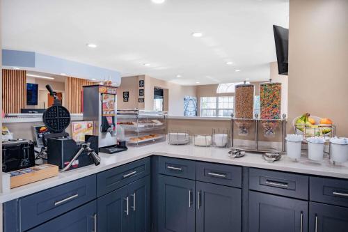 a kitchen with blue cabinets and white counter tops at Super 8 by Wyndham Joliet in Joliet