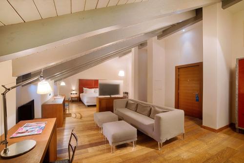 a living room with a couch and a table at NH Collection Torino Santo Stefano in Turin