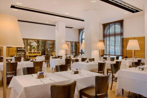 a dining room with white tables and chairs at NH Collection Torino Santo Stefano in Turin