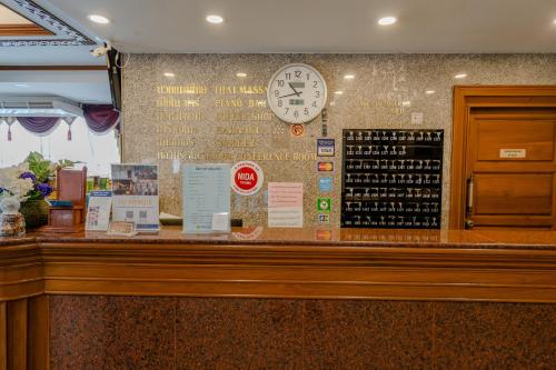 a counter with a clock on a wall at Chaipat Hotel in Khon Kaen