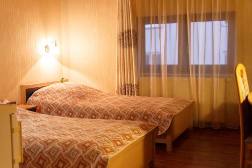 a hotel room with two beds and a window at Starye Bendery in Bender
