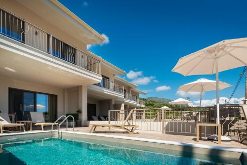 a villa with a swimming pool and an umbrella at PARGA 4 SEASONS VILLAS in Parga