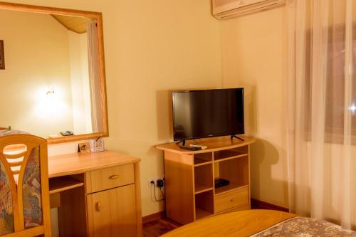a room with a television on a stand with a table at Starye Bendery in Bender