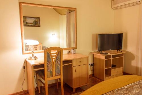a room with a desk with a television and a mirror at Starye Bendery in Bender