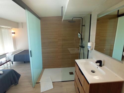 uma casa de banho com um chuveiro, um lavatório e um espelho. em Bahia Rooms Cantabria 3000 em Santander