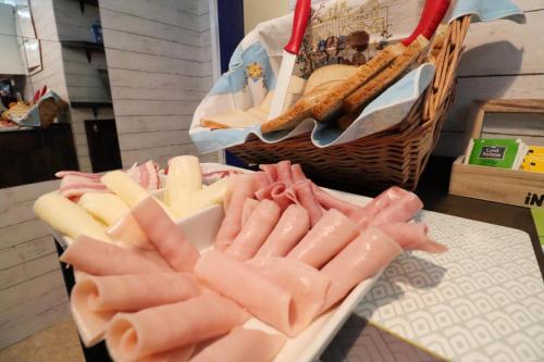 a plate of cheese and a basket of bread at Beach House Lanzarote in Arrecife