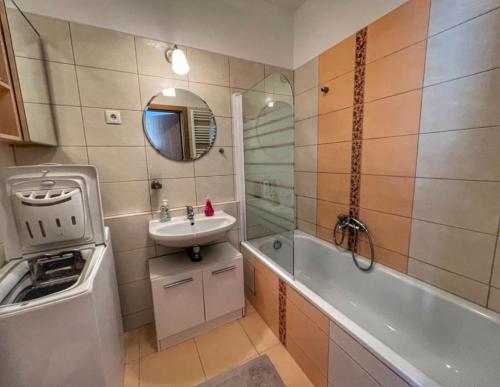 een badkamer met een wastafel, een bad en een wastafel bij Studio Viva - Cosy Flat in Budapest - Free Parking in Boedapest