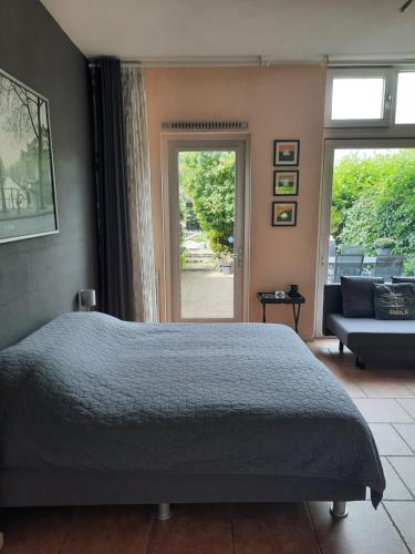 a bedroom with a bed and a couch and a window at Quarenta Studio in Amsterdam