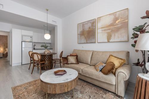 sala de estar con sofá y mesa en Apartamentos Puerta Elvira Suites 3000 en Granada